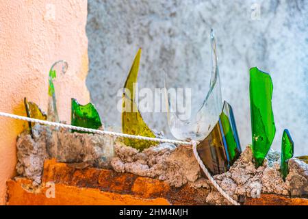 Gefährliche Wand mit zerbrochenen Glasflaschen Scherben in Luis Donaldo Colosio Playa del Carmen Mexiko. Stockfoto