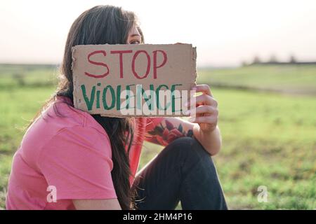 Frau bedeckt ihr Gesicht mit einer STOP VIOLENCE carter Stockfoto