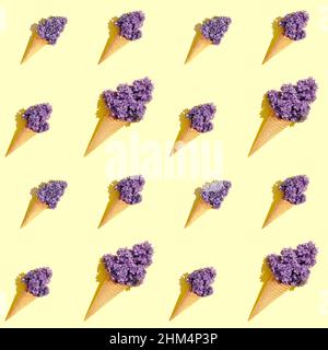 Nahtloses Muster mit Eiswaffelkonen und Fliederblüten auf gelbem Hintergrund mit harten Schatten. Sommermuster mit Fliederblüten auf einem Stockfoto