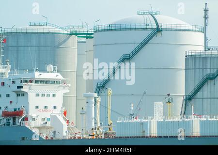 Öltanker mit einem Hintergrund von Lagertanks für Öllager im Hafen von Rotterdam, Niederlande Stockfoto