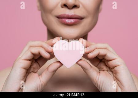 Beschnittene Ansicht einer verschwommenen Frau, die einen herzförmigen Blender in rosa gehalten hat Stockfoto