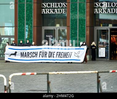 Braunschweig, 8. Januar 2022: Mitglieder einer rechtsextremen Partei, die Atemschutzmasken trägt, halten ein Plakat hinter einer Barrikade mit der Aufschrift „Ma Stockfoto