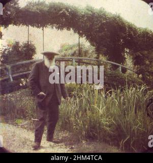 Claude Monet (1840-1926) der französische Impressionist, der 1917 in seinem Garten in Giverny, Frankreich, von Etienne Clémentel (1864-1936) mit dem von den Brüdern Lumière entwickelten Autochrome Lumière-Verfahren der Farbfotografie fotografiert wurde. Stockfoto