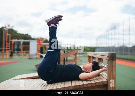 Junge Frau trainiert im Fitnessstudio im Freien Stockfoto