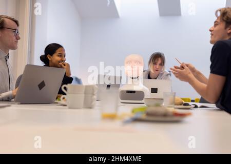 Geschäftsleute diskutieren während des Meetings über den Roboter-Sprachassistenten Stockfoto