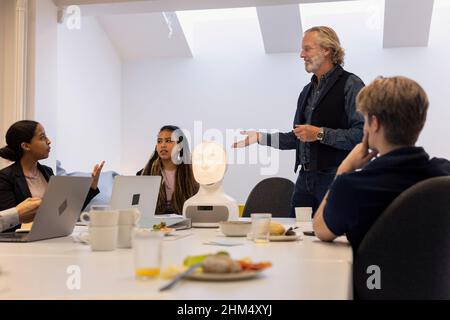 Geschäftsleute diskutieren während des Meetings über den Roboter-Sprachassistenten Stockfoto