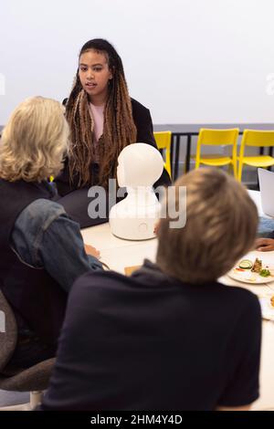 Geschäftsleute diskutieren während des Meetings über den Roboter-Sprachassistenten Stockfoto