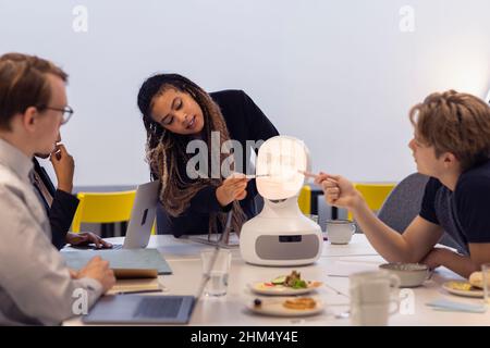 Geschäftsleute diskutieren während des Meetings über den Roboter-Sprachassistenten Stockfoto