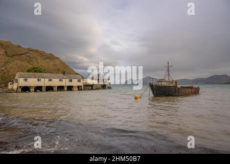 Das Boot und die Bootshäuser liegen an einem Wintertag in Richtung Traeth Porthdinllaen auf der Llyn Peninsula Wales Stockfoto