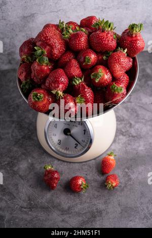 In einer Schupfschale werden frische, saftige Erdbeeren gewogen. Von oben Stockfoto