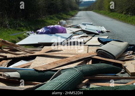 Nahansicht der Räumungsfliege im Haushalt kippte auf eine schmale Landstraße und blockierte sie fast, was ein gefährliches Verkehrsproblem verursachte. Stockfoto