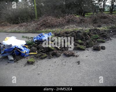 Man kann den von Fliegen gekippten Gartenmüll über ein öffentliches Wegerecht aus der Nähe betrachten Stockfoto