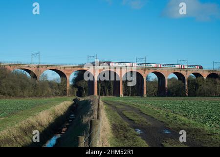 Personenzug über Eisenbahnviadukt über Ackerland in der Grafschaft Durham Stockfoto