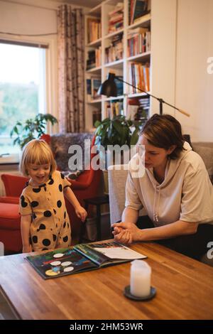 Mutter und Tochter lesen zu Hause Buch Stockfoto