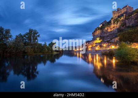 Chateau Beynac lange nach Sonnenuntergang mit dem Fluss Dordogne und Dorflichter, die sich im Wasser Beynac Dordogne France spiegeln Stockfoto