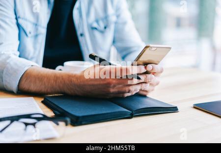 Unternehmer mit Smartphone im Arbeitsbereich Stockfoto