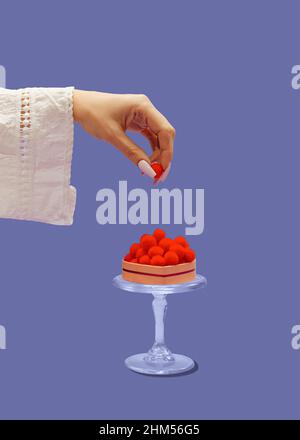 Eine Frauenhand legt kleine rote Kugeln auf eine dekorative Glasplatte. Herzförmige Box mit roter Dekoration gefüllt. Süßes Dessert für Verliebte. Ein einfaches Val Stockfoto