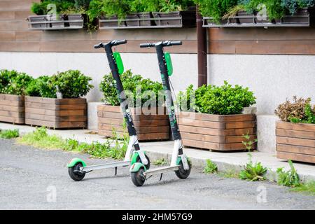 Bukarest, Rumänien, 24. Mai 2020 - zwei Kalk-Elektro-Scooter auf einer Seitenarbeit vor einem Restaurant geparkt, alternative Transportlösung Stockfoto