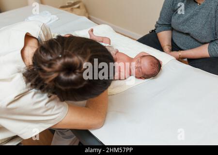 Physiotherapeutin, die mit einem Neugeborenen in einem medizinischen Zentrum arbeitet. Stockfoto