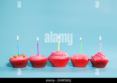 Geburtstagskuchen mit Kerzen, auf blauem Hintergrund mit Kopierplatz. Stockfoto