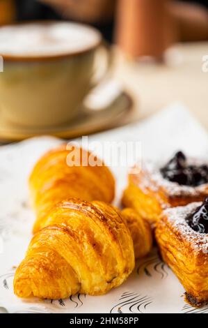 Croissant und dänisches Gebäck auf dem Frühstückstisch Stockfoto