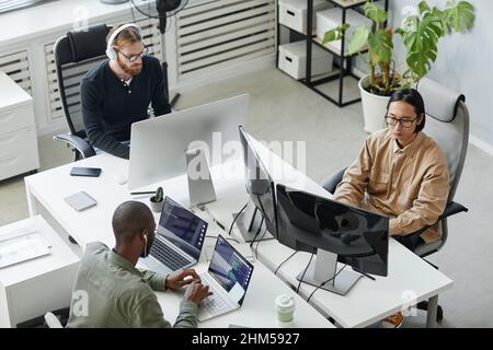Gruppe von jungen Programmierern für interkulturelle Vielfalt, die neue Programme in einem zeitgenössischen Entwicklungsbüro entwickeln Stockfoto
