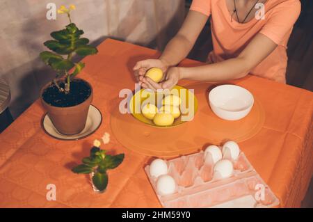 Mädchen malt ostereier mit Aquarellfarben in Gelb Stockfoto