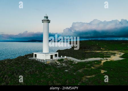 Weißer Leuchtturm an der Küste der Ozeanklippen Wolken, die von Drohnen erfasst wurden Stockfoto