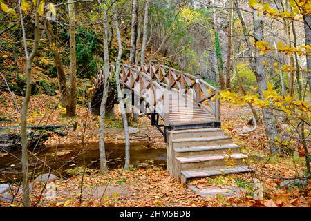 Holzbrücke und kleiner Fluss unter Hängebrücke aus Holz, getrocknete Blätter und Herbstfarben im oktober in Bursa. Stockfoto