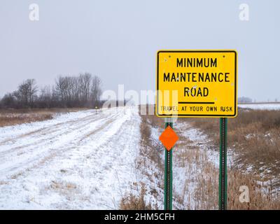 Gelbes Straßenschild Warnung vor MINIMALER WARTUNGSSTRASSE im ländlichen Minnesota Stockfoto