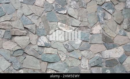 Plattenstein in Form einer Kombination von verschiedenen grauen Steinplatten Hintergrund. Stockfoto