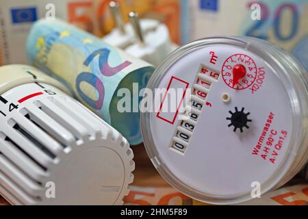 Wasserzähler, Thermostat und Banknoten symbolisieren zusätzliche Mietkosten Stockfoto