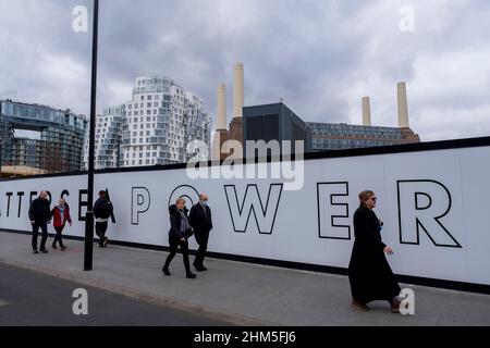 Am 3rd. Februar 2022 passieren Menschen in London, England, Großbritannien, Haufenplätze rund um die Sanierung des Battersea Power Station und seiner Umgebung. Das Battersea Power Station ist ein stillgelegtes Kohlekraftwerk am Südufer der Themse in Nine Elms, Battersea, einem innerstädtischen Viertel im Südwesten Londons. Jetzt eine gut fortgeschrittene Baustelle und in der Entwicklung, wird die Website sowohl Wohn-und Gewerbegebiet. Stockfoto