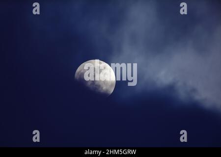 Mond hinter dunkelblauen Wolken Stockfoto