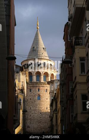Istanbul, Türkei - 29. Dezember 2022 : Touristen mit medizinischen Masken am Galata-Turm. Sie beobachten die Landschaft Istanbuls bei Sonnenuntergang. Stockfoto