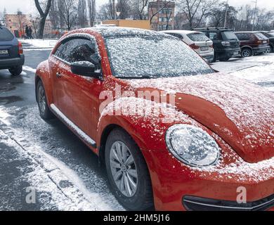 Kiew, Ukraine. 1. Januar 2022. Schöne rote Retro Volkswagen Marke Automobil geparkt auf der Straße bei verschneiten Wintertag. Legendäres Auto auf der Stadtstraße in der Stadt Stockfoto