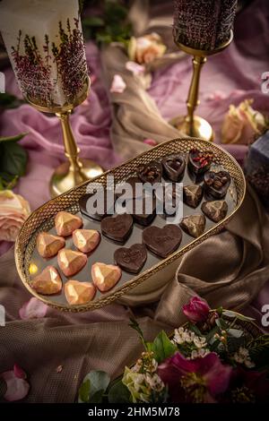 Verschiedene Schokoladenpralinen auf luxuriösem Hintergrund, Stillleben zum Valentinstag Stockfoto