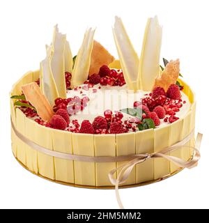 Ganze weiße Schokoladenkuchen mit Himbeeren und roten Johannisbeeren auf weißem Hintergrund isoliert dekoriert Stockfoto