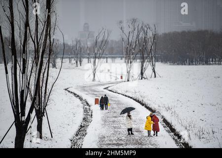 Wuhan, China. 07th. Februar 2022. Während eines Schneefalls in Hubei gehen Menschen im Jiangtan Park.Wuhan leitete den ersten Schneefall des chinesischen Neujahrs ein. Kredit: SOPA Images Limited/Alamy Live Nachrichten Stockfoto