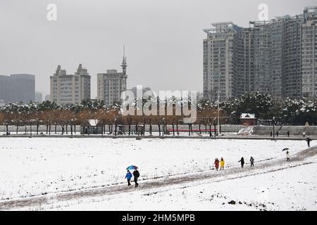Wuhan, China. 07th. Februar 2022. Menschen gehen im Jiangtan Park während eines Schneefalls Hubei.Wuhan leitete den ersten Schneefall des chinesischen Neujahrs ein. Kredit: SOPA Images Limited/Alamy Live Nachrichten Stockfoto