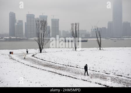 Wuhan, China. 07th. Februar 2022. Ein Mann geht während eines Schneefalls in Hubei im Jiangtan Park spazieren.Wuhan leitete den ersten Schneefall des chinesischen Neujahrs ein. Kredit: SOPA Images Limited/Alamy Live Nachrichten Stockfoto