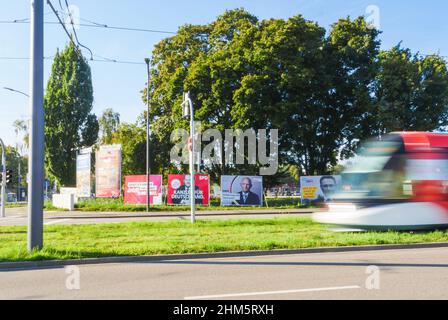 Kehl, 24. Sep 2021: Straßenbahn vor Wahlplakaten mit den Kanzlerkandidaten der SPD mit Olaf Scholz, CDU mit Armin Laschet und Bundnis 90 die Grunen mit Annalena Baerbock. Deutsche Bürger sind zur Wahl eines neuen Bundestages aufgerufen. Stockfoto