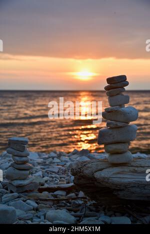 Friedlich, ruhig, ein Haufen von balancierten und gestapelten Felsen und Steinen an einem felsigen, mit Kieselsteinen gefüllten Strand in Door County, Ellison Bay, Wisconsin, USA Stockfoto