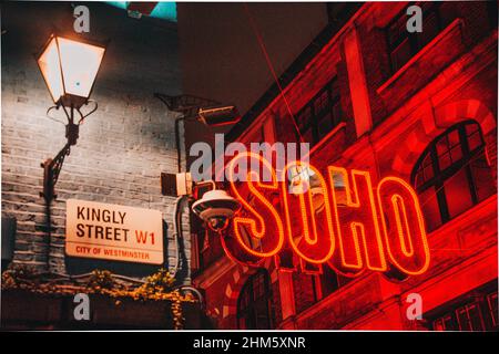Nahaufnahme eines Neonschildes, das in der Nacht in Soho aufleuchtet. Stockfoto