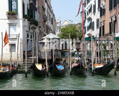 Gondeln am Canale Grande in Venedig. Die schwarzen Gondeln sind Teil des unverwechselbaren Bildes Venedigs, hier an einer Anlegestelle am Canale Grande. Stockfoto