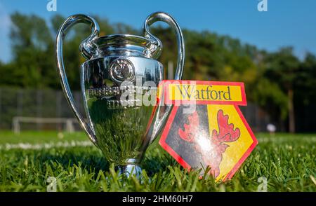 30. August 2021, Moskau, Russland. Das Watford Football Club Emblem und der UEFA Champions League Cup auf dem grünen Rasen des Stadions. Stockfoto