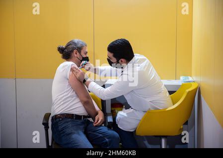 Teheran, Teheran, Iran. 5th. Februar 2022. Eine iranische junge Frau, die eine schützende Gesichtsmaske trägt, erhält im Einkaufszentrum Iranmall im Nordwesten von Teheran eine Dosis des südkoreanischen Impfstoffs gegen die neue Coronavirus-Krankheit AstraZeneca (COVID-19). (Bild: © Sobhan Farajvan/Pacific Press via ZUMA Press Wire) Stockfoto