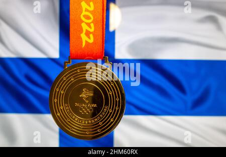 5. Januar 2021, Peking China. Goldmedaille der XXIV. Olympischen Winterspiele vor der Flagge Finnlands. Stockfoto