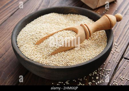 Quinoa-Körner in einer Holzschüssel auf einem Holztisch. Stockfoto