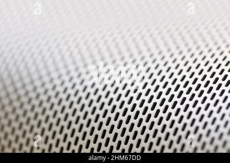 Abstraktes Makro im Hintergrund aus glänzendem Aluminium-Blech mit Löchern, selektiver Fokus Stockfoto